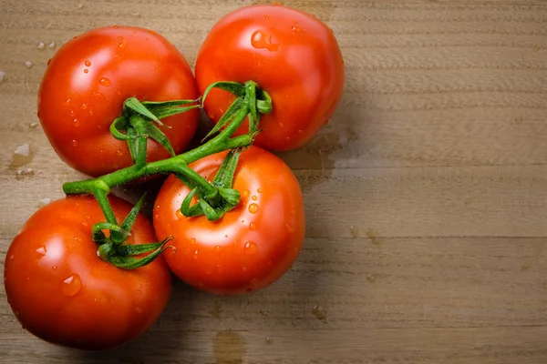 Tomates panículas em uma tábua de corte de madeira — Fotografia de Stock