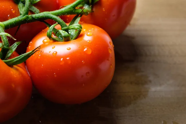 Tomates panículas em uma tábua de corte de madeira — Fotografia de Stock