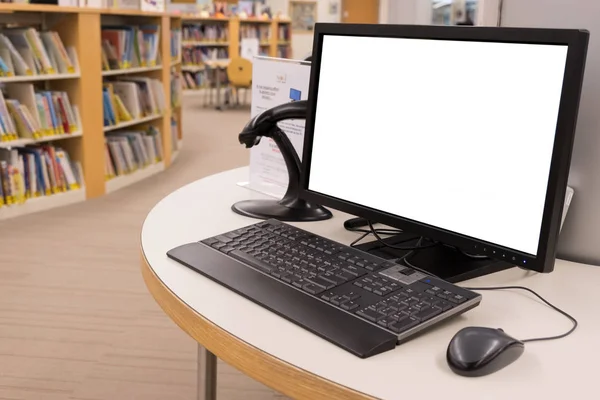 Ordenador con monitor de pantalla en blanco en la mesa en la biblioteca interior —  Fotos de Stock