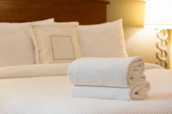 Witte handdoek op bed in hotelkamer — Stockfoto