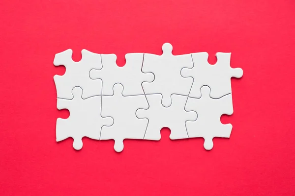 Eight pieces white jigsaw puzzle on red background for business presentation — Stock Photo, Image