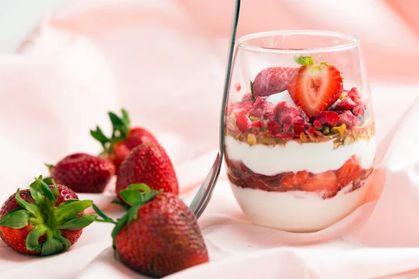 Strawberry yogurt with muesli on pink background — Stock Photo, Image
