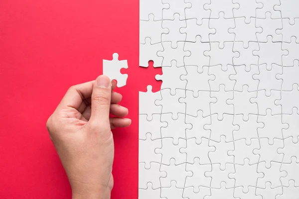 Hand putting the last piece of white puzzle for business concept or content background — Stock Photo, Image