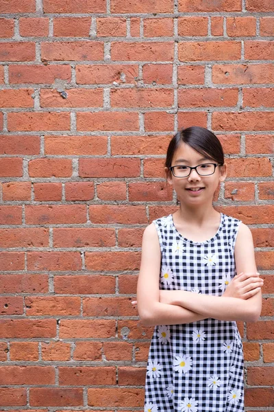 Porträt eines jungen asiatischen Mädchens gegen rote Backsteinmauer — Stockfoto