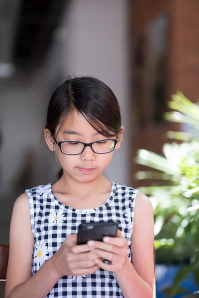 Дівчина-підліток за допомогою смартфона в кафе — стокове фото