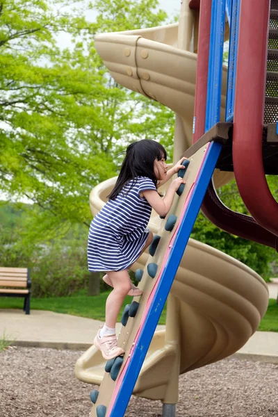 Cute little girl is climbing up on ladder in playground — Stock Photo, Image