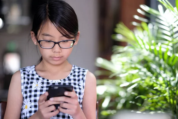 Una chica adolescente usando un teléfono inteligente en la cafetería — Foto de Stock