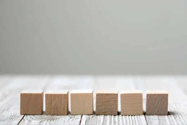 Seis cubos de juguete de madera sobre fondo gris de madera — Foto de Stock