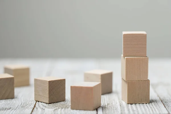 Drie houten speelgoed kubussen op grijze houten achtergrond — Stockfoto