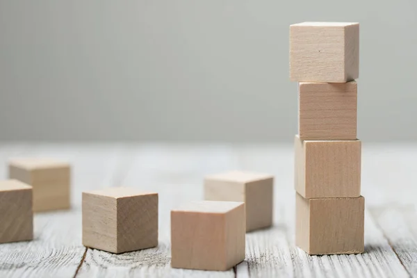 Vierhouten speelgoed kubussen op grijze houten achtergrond — Stockfoto