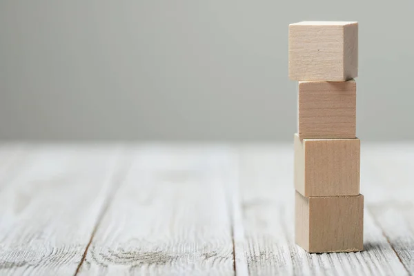 Четыре деревянных кубика игрушки на сером деревянном фоне — стоковое фото