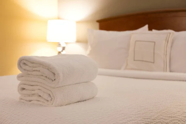 Przytulny pokój hotelowy z ręcznikami kąpielowych na łóżku — Zdjęcie stockowe