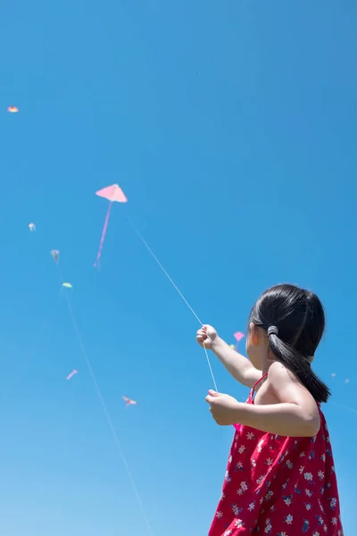 Küçük kız güneşli yaz gününde bir uçurtma uçan — Stok fotoğraf