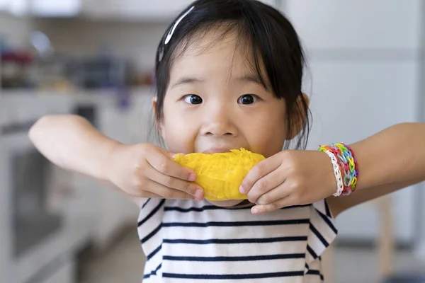 Щаслива дівчинка їсть манго — стокове фото
