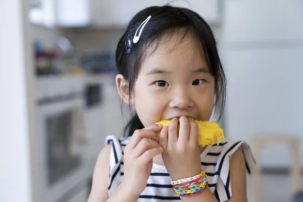 Felice bambina mangiando mango — Foto Stock