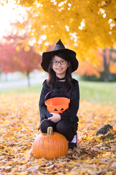 Portrait of little asian girl in witch costume