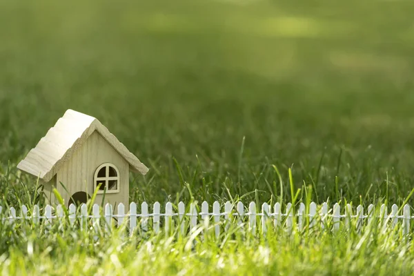 Pequeña casa en la hierba en la luz del sol —  Fotos de Stock