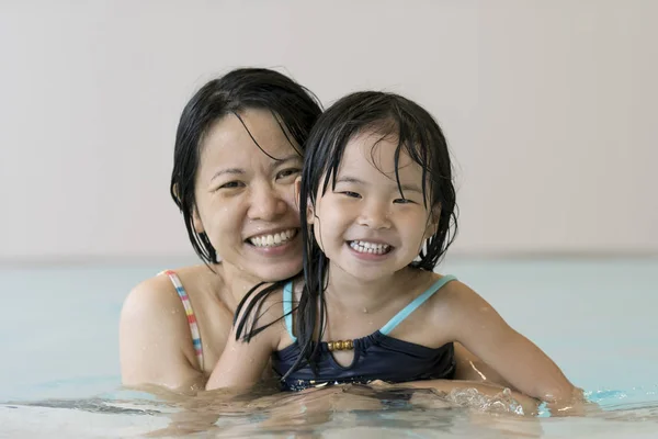 Happy mother and baby daughter at swimming pool — Stock Photo, Image