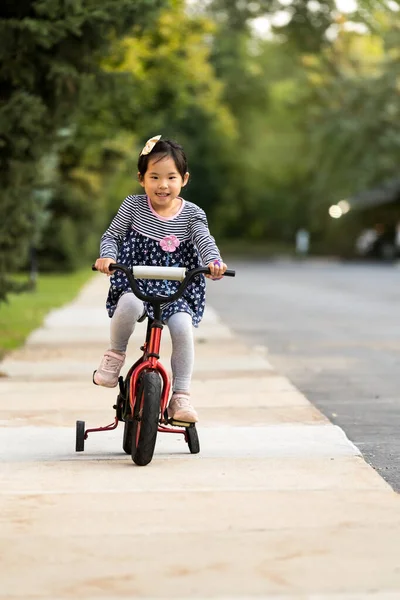 Bonito menina aprendendo a andar de bicicleta sem capacete — Fotografia de Stock