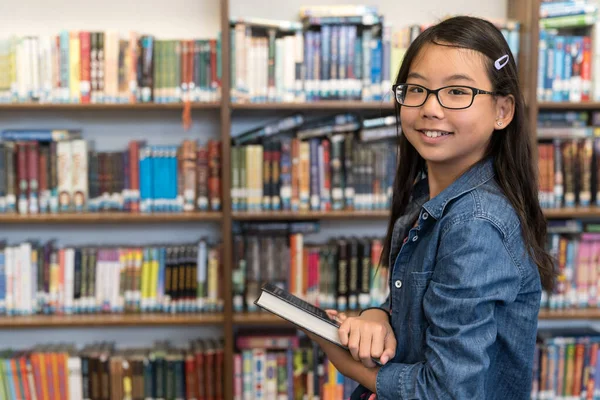 Asiática adolescente chica con gafas en la escuela biblioteca — Foto de Stock
