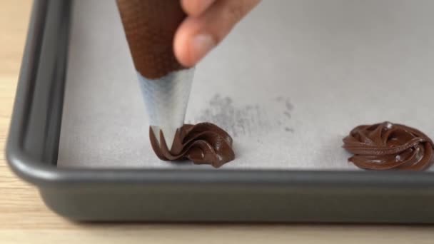 Manos tuberías galletas de chocolate en bandeja para hornear Fotografías de stock