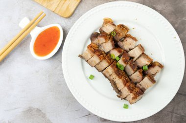 Kızarmış domuz eti, beyaz tabakta servis edilir.