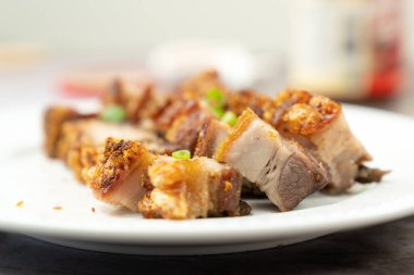 Kızarmış domuz eti, beyaz tabakta servis edilir.