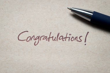 El yazısıyla yazılmış bir tebrik mektubu. Mürekkeple yazılmış. Kutlamayı, başarıyı ve olumlu tanınmayı simgeliyor..