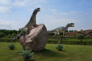 Leba, Polonya - 23 Temmuz 2013: Allosaurus modelleri ve Komodo dragon.