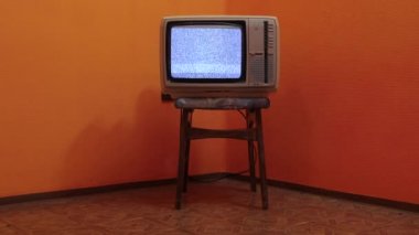 Boş bir odadaki sandalyeye eski bir televizyon.