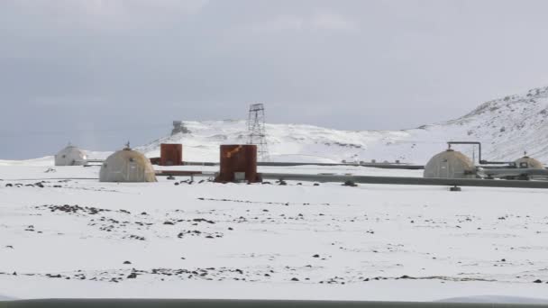 Geothermal power plant wells on snowy landscape — Stock Video