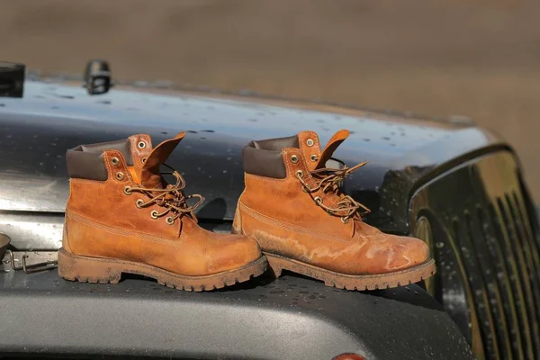 Boots on the hood of a car — Stock Photo, Image
