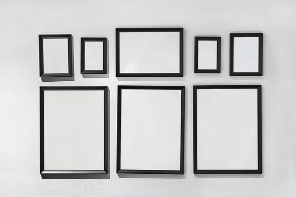 Blank picture frames on white wall — Stock Photo, Image