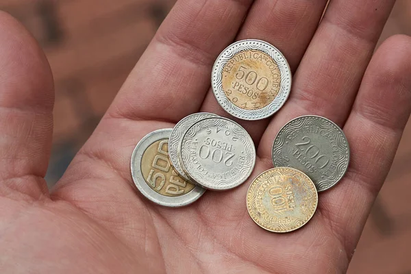 Colombianska peso mynt hålls i handen — Stockfoto