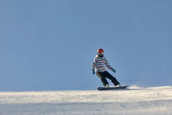 Kvinna snowboardåkare i soleruption — Stockfoto