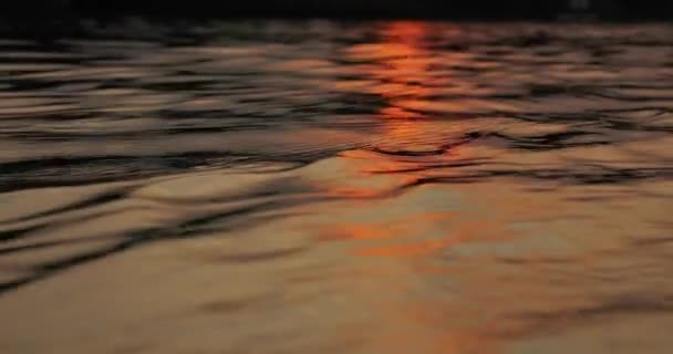 Zonsondergang boven een rustig meer, reflectie van de watergolf — Stockvideo