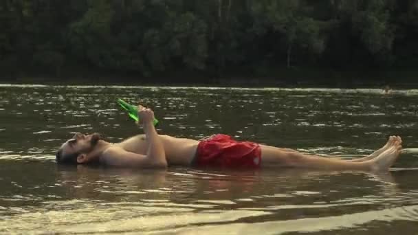 Homme ivre couché en eau peu profonde — Video