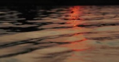 Sakin bir gölün üzerinde gün batımı, su dalgası yansıması