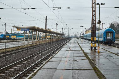 Yolcu trenleri yağmurda giden tren istasyonu.