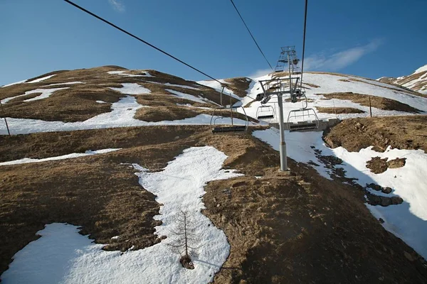 Ski lift σε ένα χιονοδρομικό κέντρο με λίγο χιόνι — Φωτογραφία Αρχείου