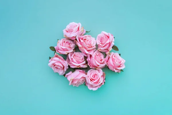 几个缎粉红色的玫瑰芽在绿色粉彩背景 顶部视图 — 图库照片