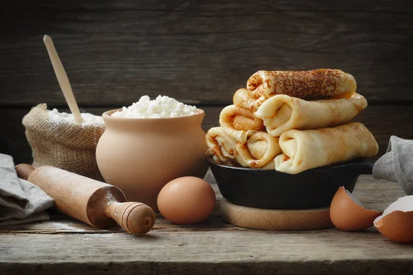 Frying pan of baked pancakes, ingredients and kitchenware for pancakes making. — Stock Photo, Image