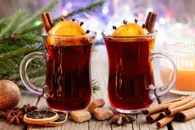 Cam bardağı sıcak baharat ve turunçgiller, Noel ağaç dalları ve bokeh arka plan ışıkları ile şarap mulled.