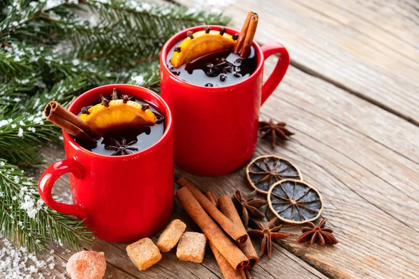 Rote Becher Glühwein Mit Gewürzen Und Zitrusfrüchten Und Schneebedeckte Christbaumzweige — Stockfoto