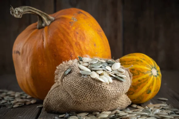 Bolsa Lona Semillas Calabaza Dos Calabazas Sobre Mesa Madera —  Fotos de Stock