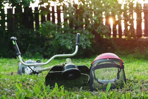 Grass trimmer on lawn in garden outdoors. — Stock Photo, Image