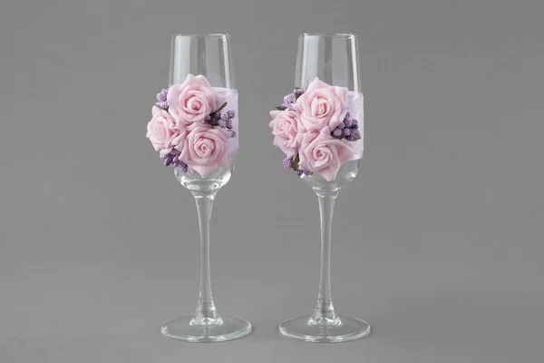 Two ornate wedding wine glasses decorated with lace and pink ros