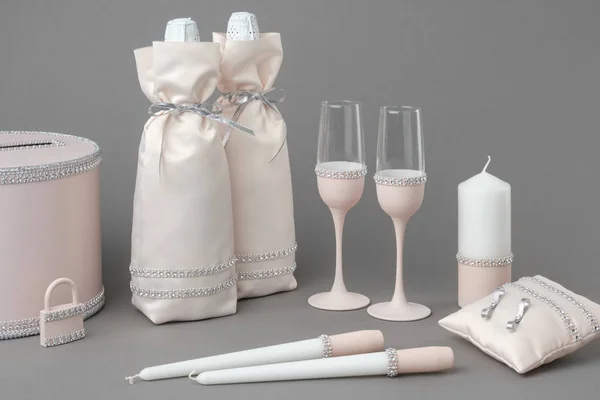 Bruiloft accessoires: flessen champagne in zakken, wijn glazen, kaarsen, doos voor geld en wensen, bruiloft slot en kussen voor ringen. — Stockfoto
