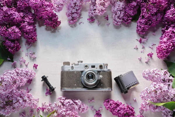 Retro camera, foto filmrollen en frame van lila bloemen. Bovenaanzicht. Ruimte kopiëren voor tekst. — Stockfoto