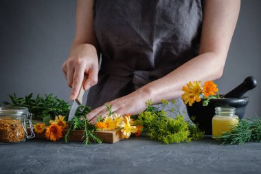 Herbalist kadın tedavi için şifalı ilaçlar hazırlamak için bir bıçak ile şifalı otlar doğrama. Bitkisel ilaç kavramı.